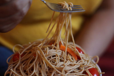 Midsection of woman holding noodles