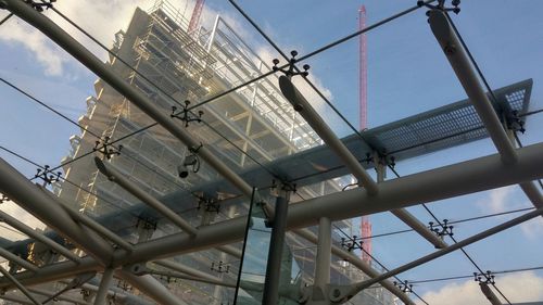 Low angle view of incomplete glass against sky seen from skylight