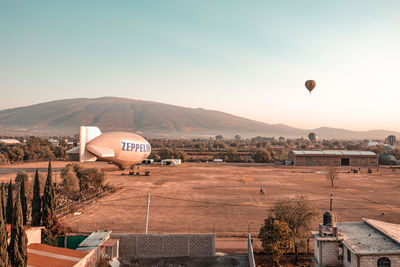 Hot air balloon over mountains against clear sky