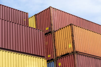 A stack of containers standing on top of each other in the loading yard by the wharf.