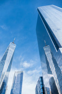 Low angle view of skyscrapers against blue sky