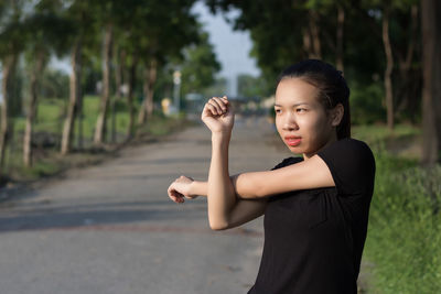 Portrait of woman standing on footpath