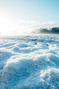 Scenic view of snow covered field against sky