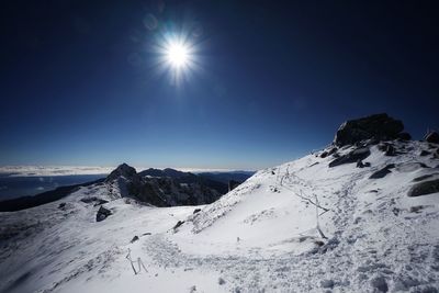 Scenic view of snowcapped mountains against clear sky during winter