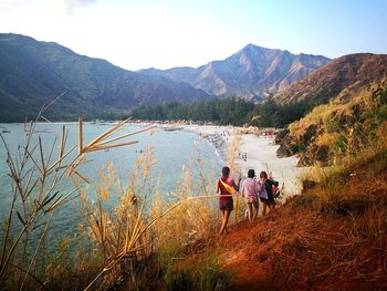 People on mountain against clear sky