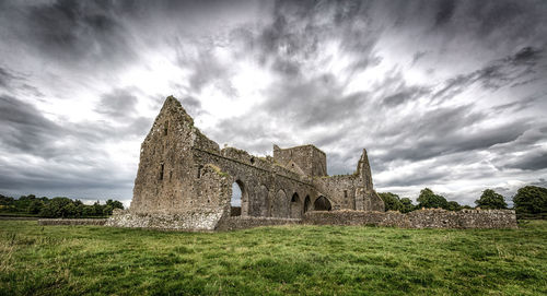 Old ruins on field against sky