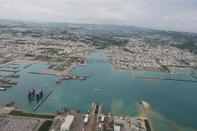 Aerial view of river by buildings in city against sky