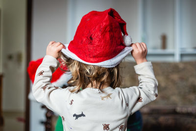 Side view of woman wearing hat standing at home