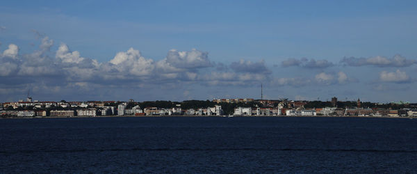 Calm sea with buildings in background