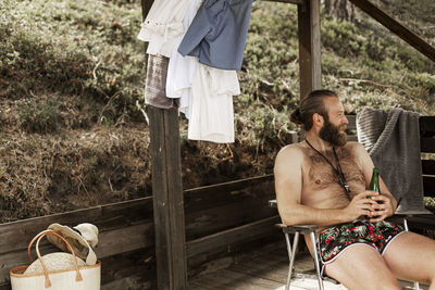 Smiling man having beer at lake