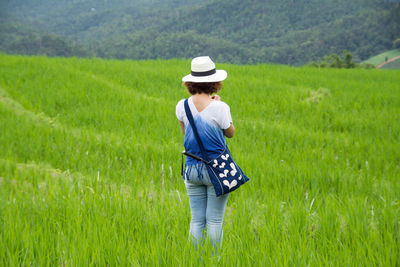 Rear view of woman standing in field