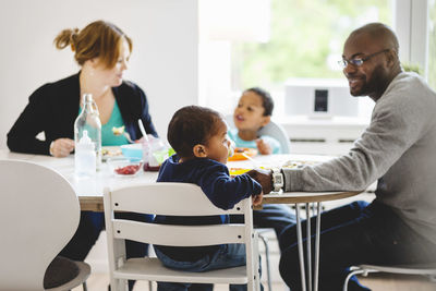 Multi-ethnic family having food at dining table in house