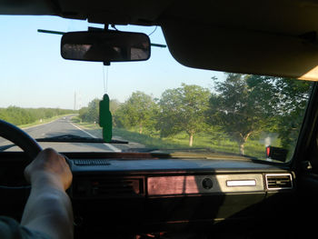 Man driving car on road against sky