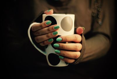 Cropped image of woman holding spotted mug