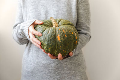 Midsection of woman holding pumpkin