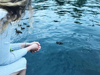 Low section of woman swimming in water