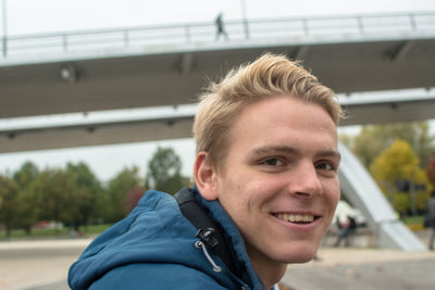 Portrait of young man smiling while sitting outdoors