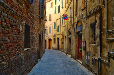 Alley amidst buildings in city of siena 