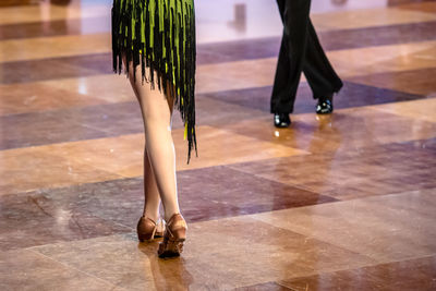 Low section of man and woman dancing on floor