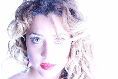 Close-up portrait of young woman against white background