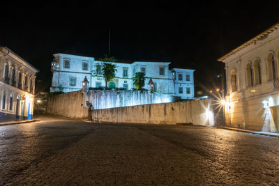 Street amidst buildings in city at night