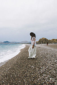 Full length of child on beach against sky