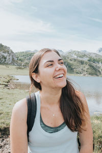 Portrait of young woman looking away against sky