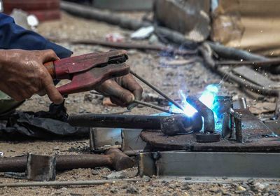 Cropped hands of man welding metal in workshop