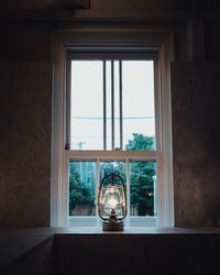 Illuminated lantern on window sill at home