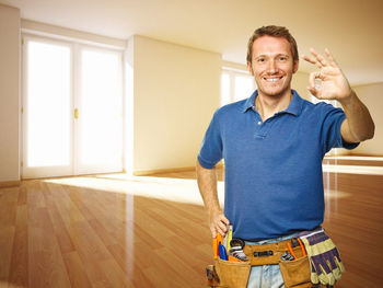 Portrait of smiling man standing on hardwood floor at home