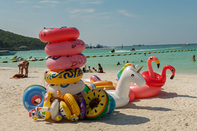 Panoramic view of swans at sea shore against sky