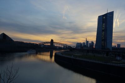 Bridge over river against cloudy sky