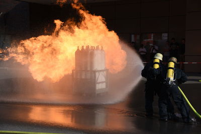 People standing by fire in water