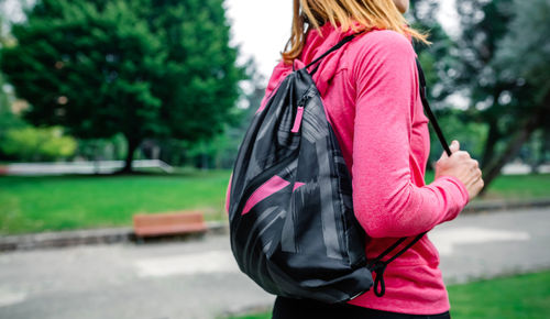 Unrecognizable athlete woman with backpack going to the gym outdoors