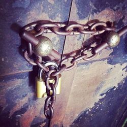 Close-up of rusty chain on wooden door