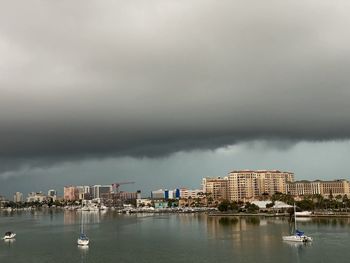 Sea by buildings against sky