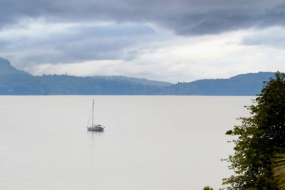 Sailboat sailing on sea against sky