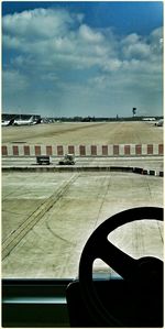 Cars on road against cloudy sky