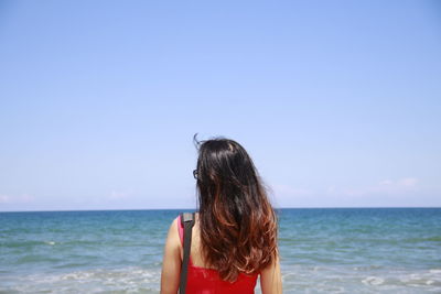 Rear view of woman looking at sea against sky