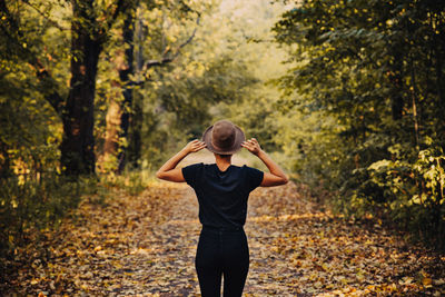 Full length of woman standing in forest