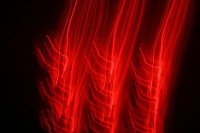 Close-up of illuminated red lights against black background