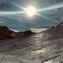 Scenic view of snowcapped mountains against sky on sunny day