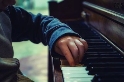 Midsection of man playing piano