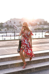 Young woman standing against railing