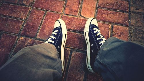 Low section of man standing on tiled floor