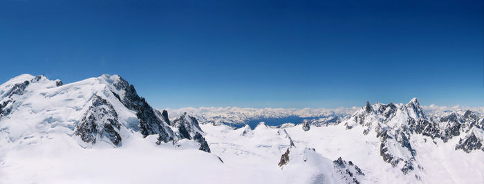 Scenic view of snow against clear blue sky