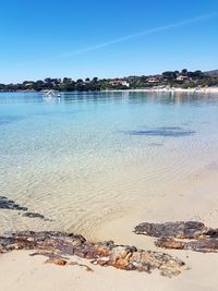 Scenic view of beach against clear blue sky