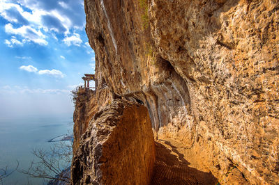 Rock formation in sea against sky