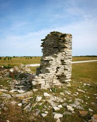 Stack of rocks on field against sky