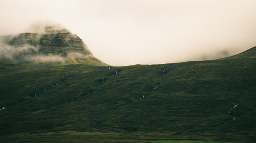 Countryside landscape against sky during foggy weather